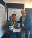 Foto: Viktor in front of his poster at “HARMO19” with award and supervisor Matthias Ketzel